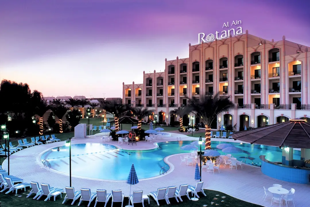 Al Ain Rotana в Эль-Айне, ОАЭ: бассейн отеля вечером